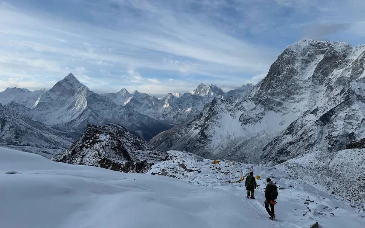 Two trekkers descending Lobuche with Ama Dablam in the distance