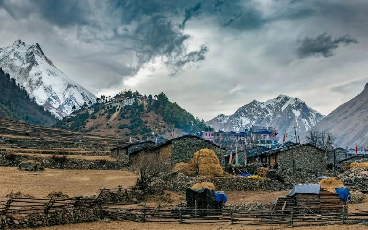 Traditional stone houses in Manaslu village with snow-capped peaks