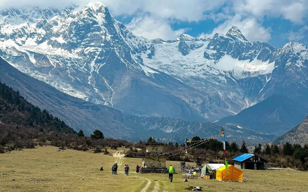 Trekkers camping with orange tents in Manaslu region