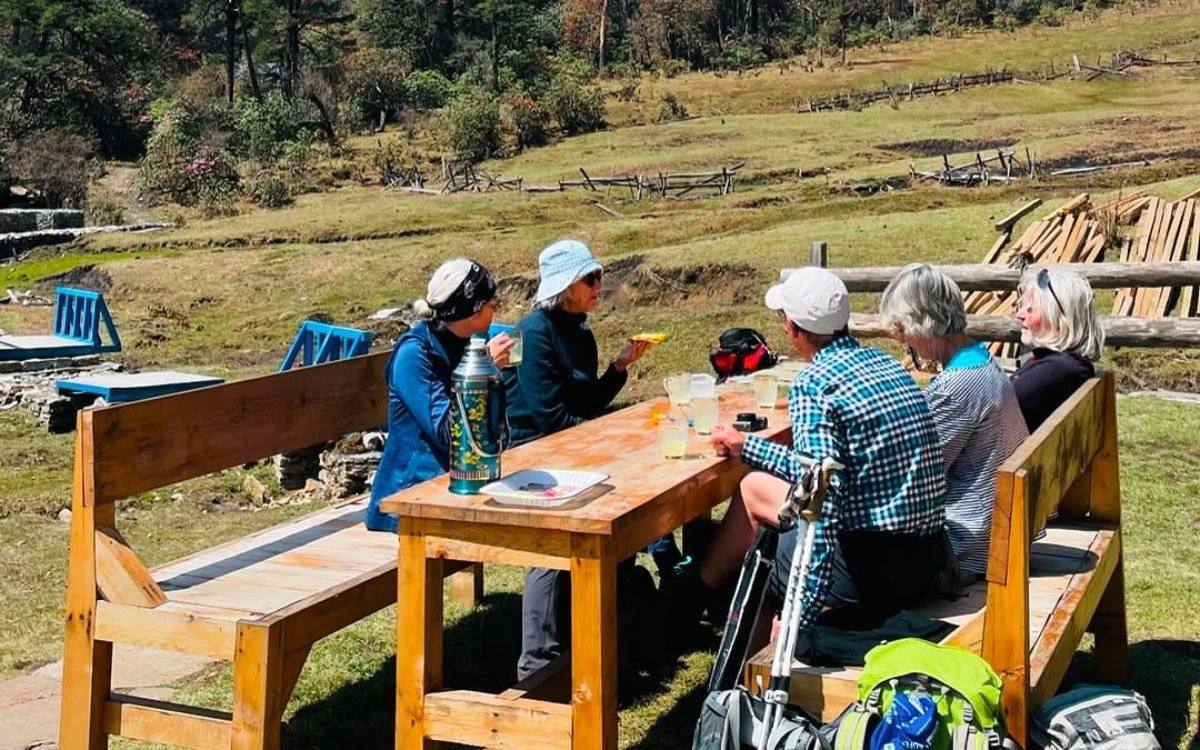 Trekkers dining at outdoor teahouse table on Pikey Peak Trek