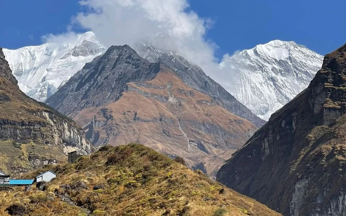 Annapurna sanctuary valley with teahouse lodges and massive snow-capped peaks on a clear October day