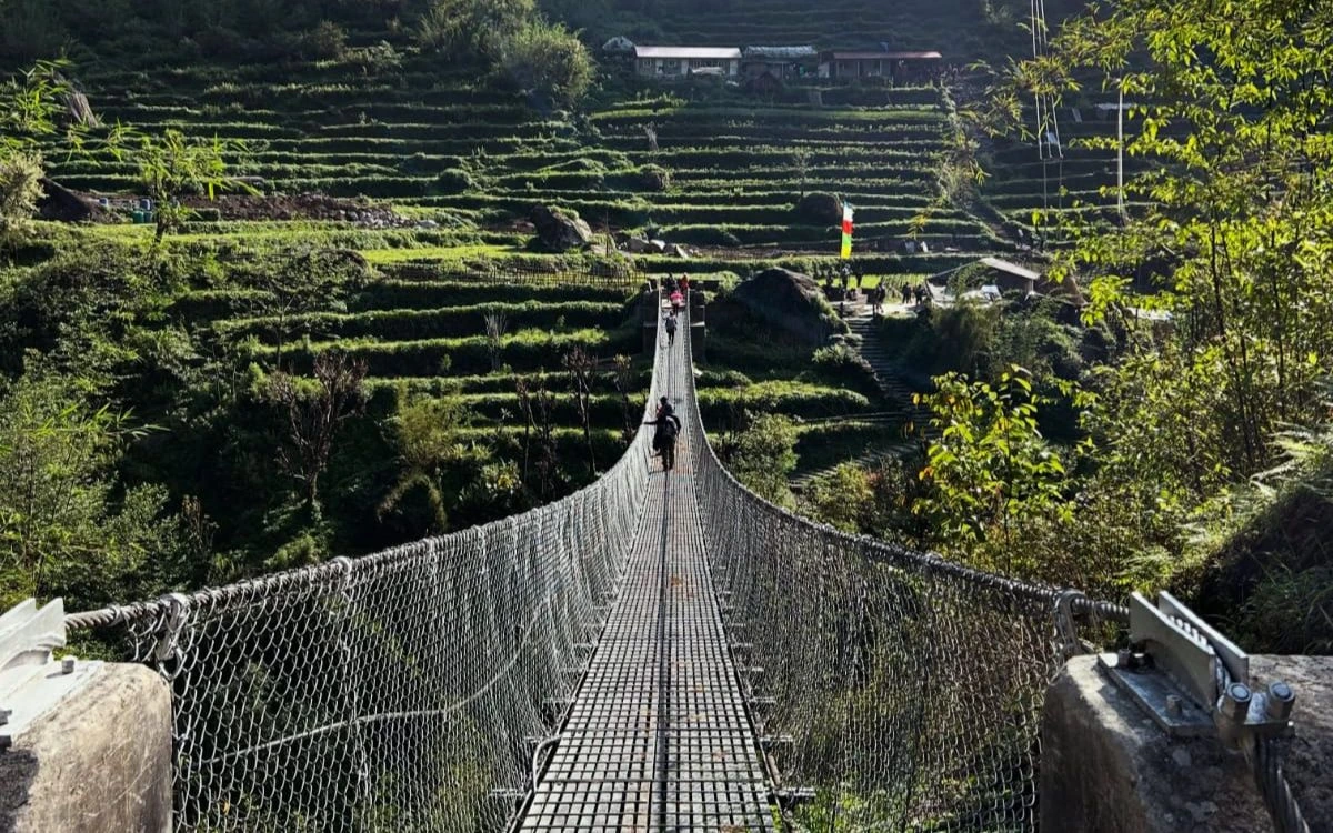 Suspension bridge over terraced fields on the Annapurna Base Camp Trek