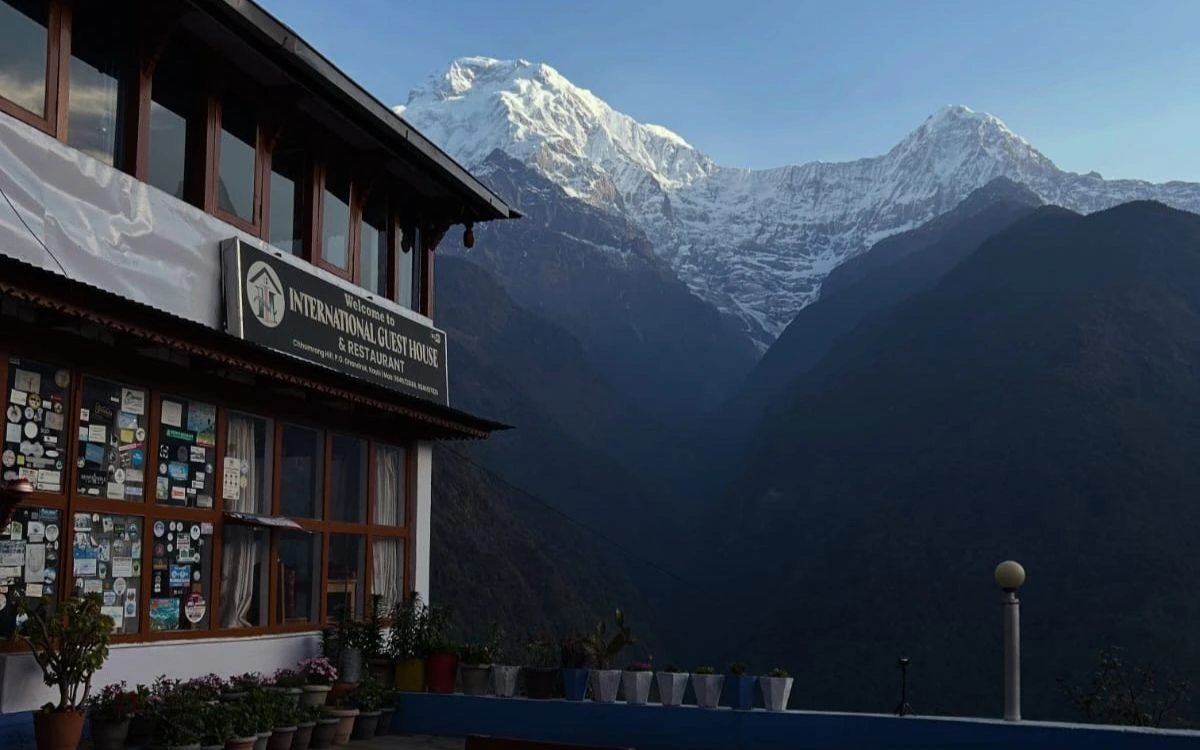 Chhomrong guesthouse with Annapurna South at sunrise on the ABC Trek