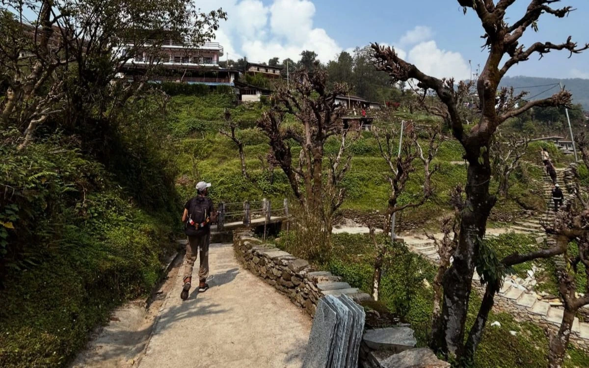 Trekker walking a village trail on the Annapurna Base Camp Trek
