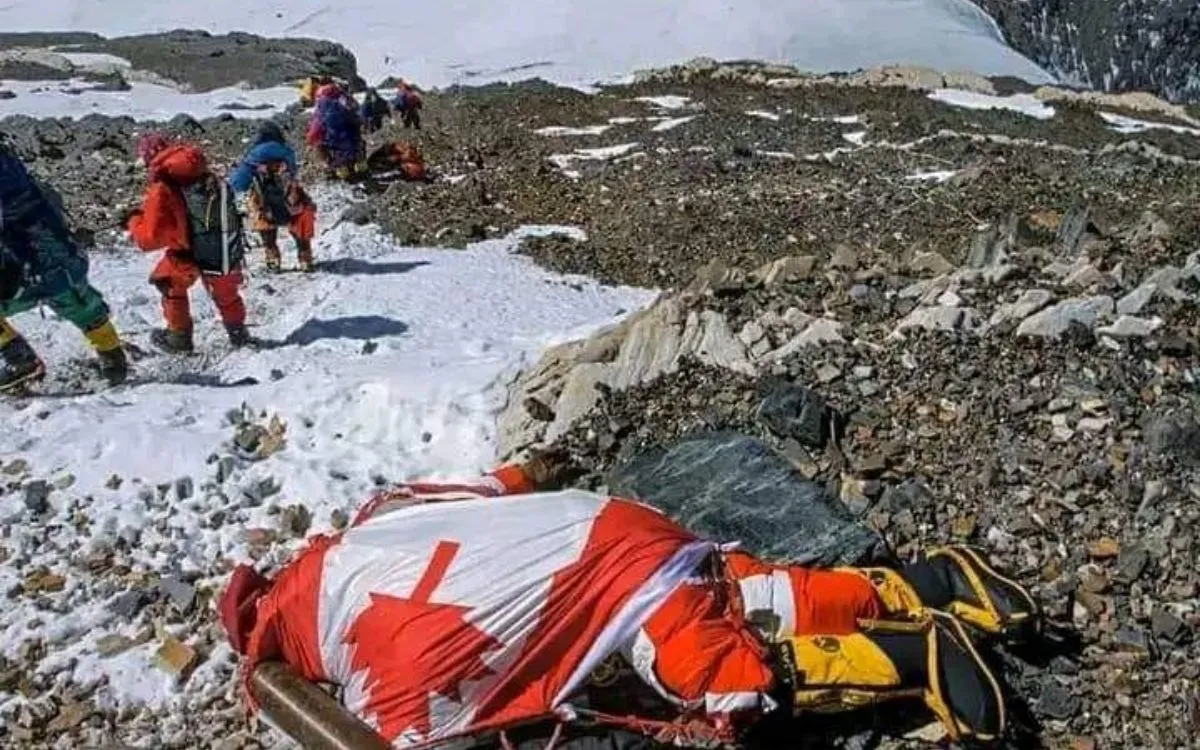 Body recovery operation on Mount Everest with climbers in orange suits working near rocky terrain