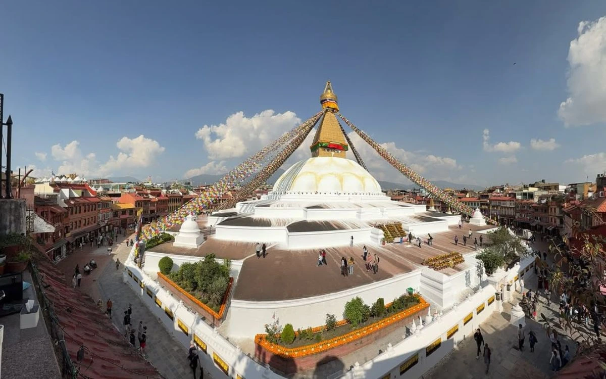 Boudhanath Stupa panoramic view with white dome, golden spire, and colorful prayer flags in Kathmandu, Nepal