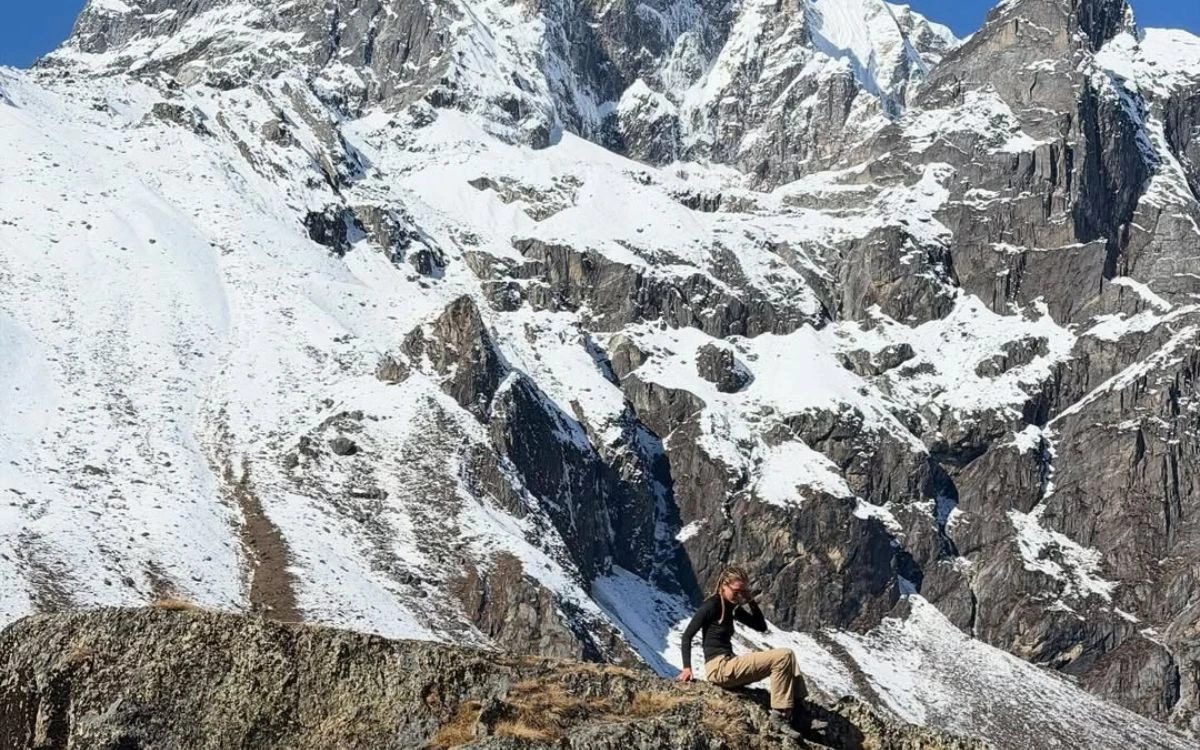 Hiker at Everest Base Camp with snow-covered Himalayan peaks background
