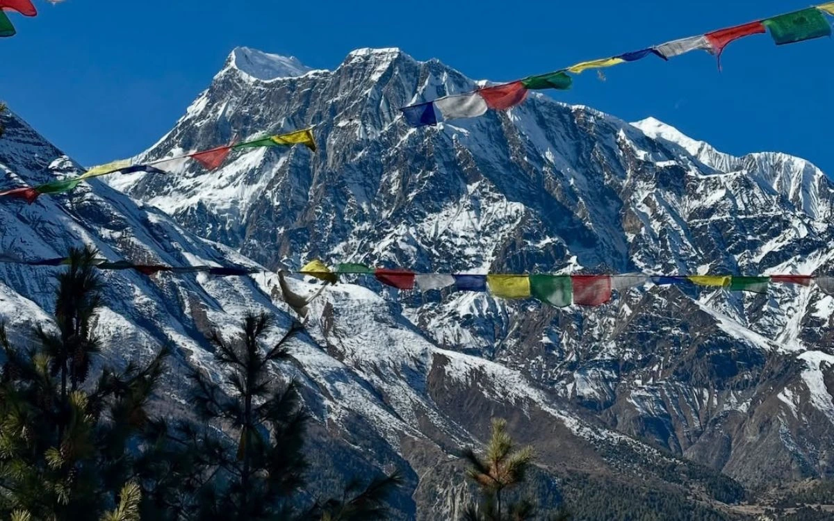 Manaslu Circuit trek prayer flags framing snow-capped peak Nepal