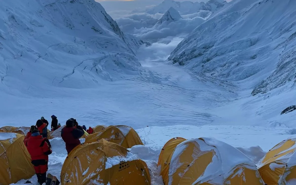Everest camp setup in snowy valley with climbers preparing gear