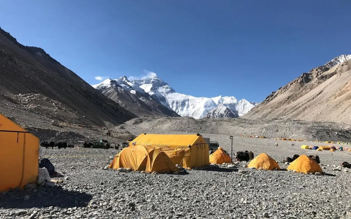 North side Everest Base Camp with orange tents on rocky terrain below summit