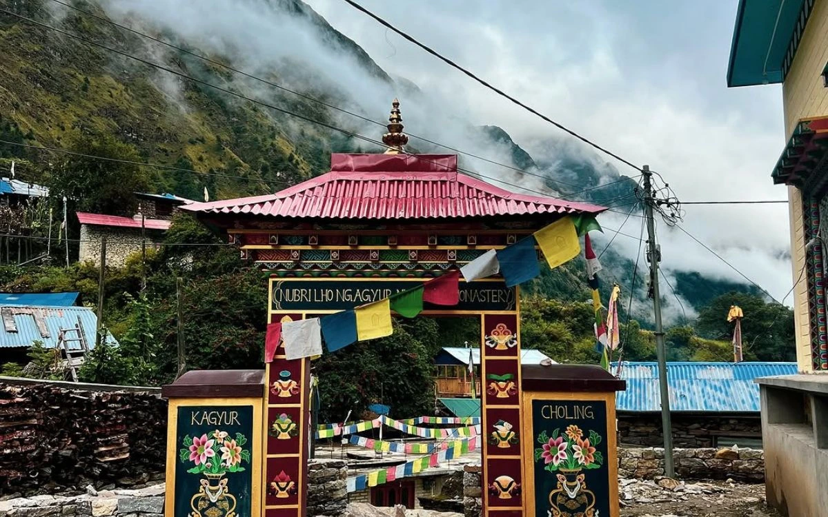 Colorful Tibetan Buddhist monastery entrance with prayer flags in mountain village