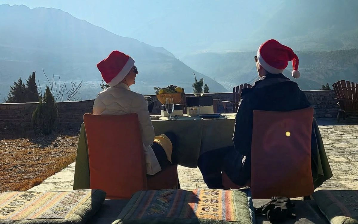 Couple wearing Santa hats enjoying Christmas dinner with Himalayan mountain views in Nepal