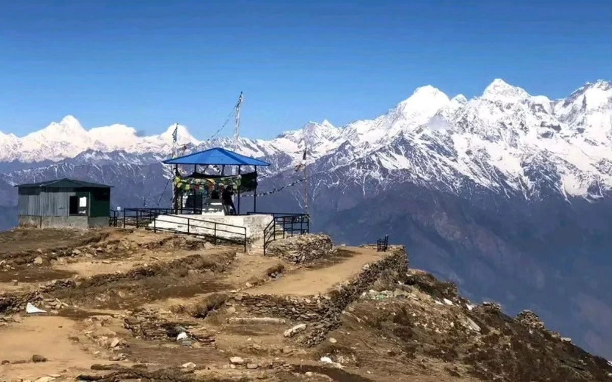 A hilltop rest stop with prayer flags and sweeping Himalayan mountain views