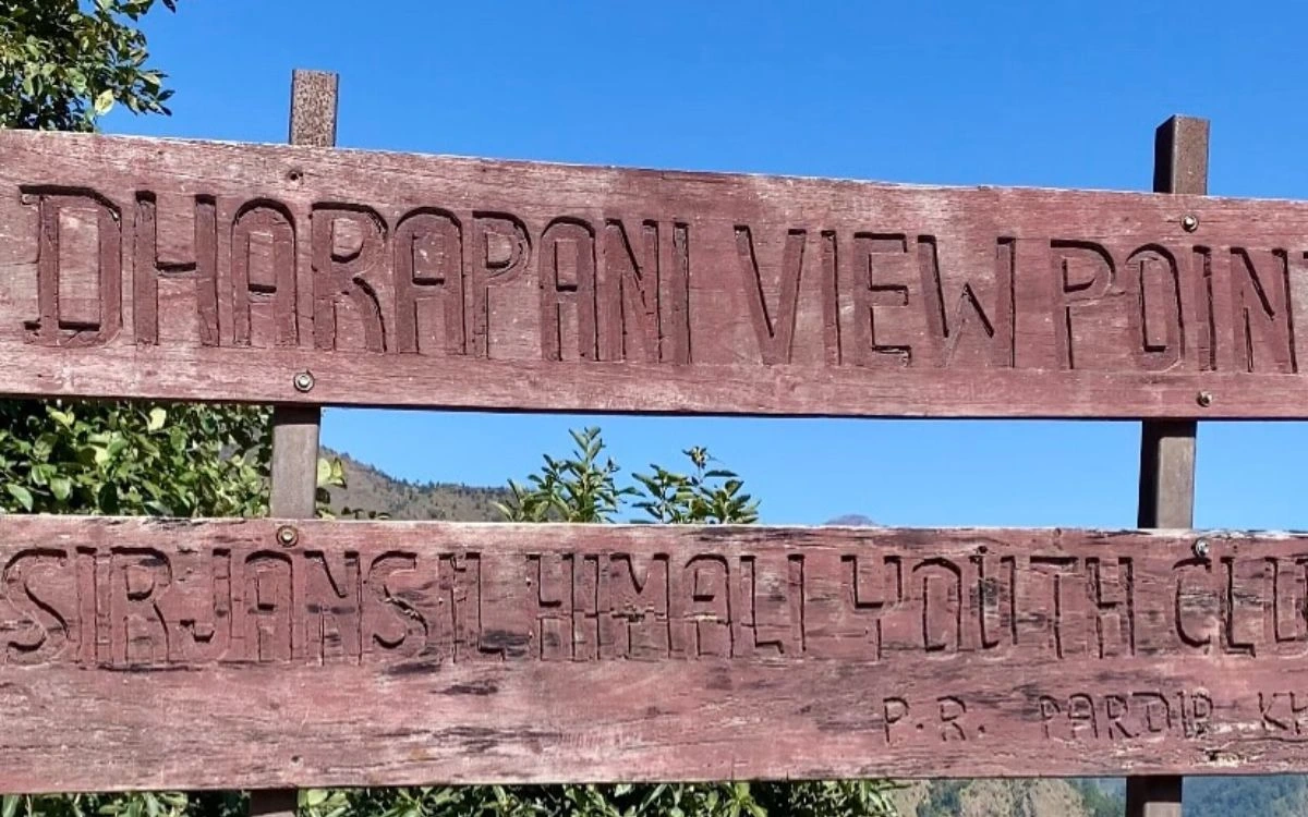Wooden entrance sign to Dharapani village with Sirjana Shimal Youth Club name carved in wood