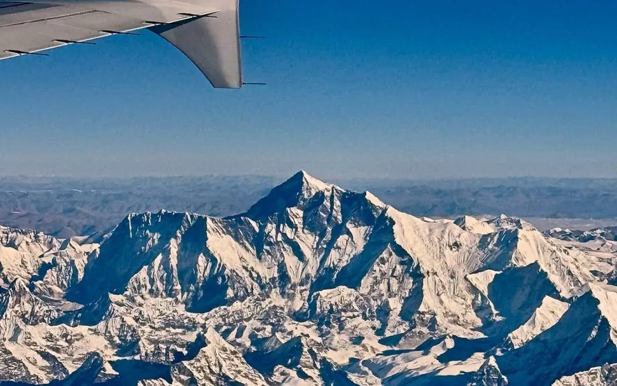 Aerial view of Mount Everest from domestic flight window showing snow-covered Himalayan peaks