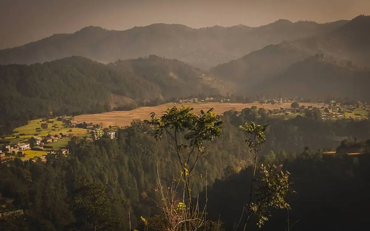 Terraced hillsides with traditional villages nestled among forested mountains in golden evening light