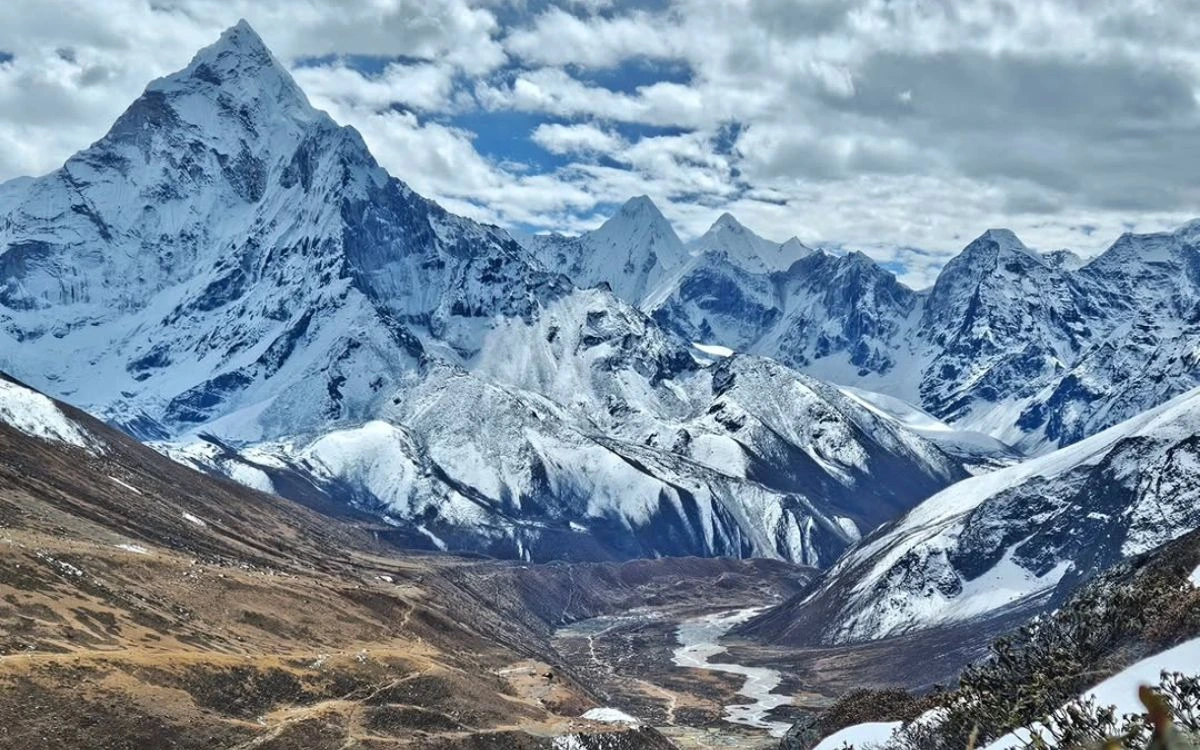 Ama Dablam and a row of Khumbu Himalayan peaks towering above a wide glacial valley in the Everest region