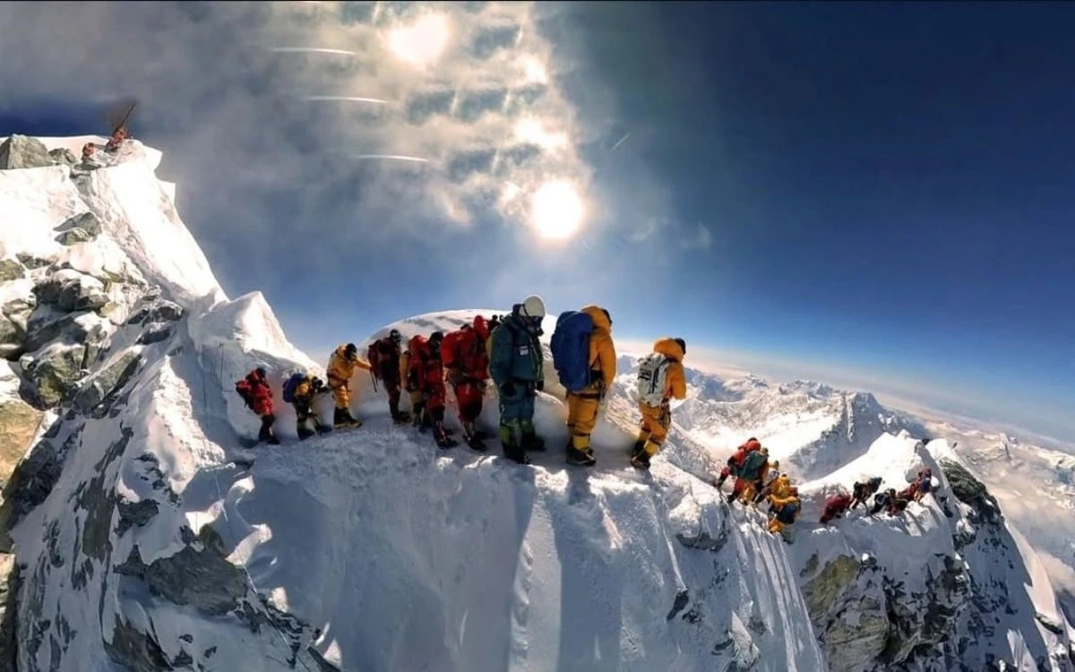 Everest traffic jam showing long line of climbers queuing on narrow summit ridge in death zone