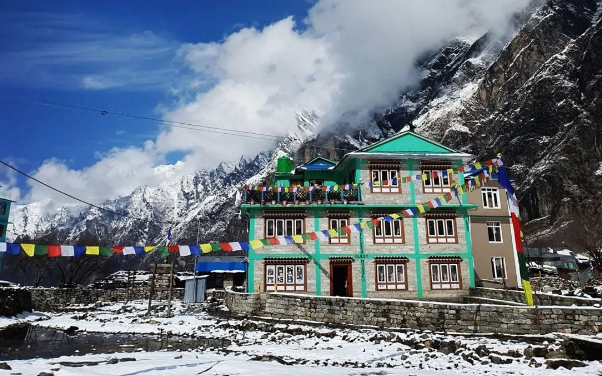 Colorful teahouse lodge with prayer flags in snowy Himalayan mountains