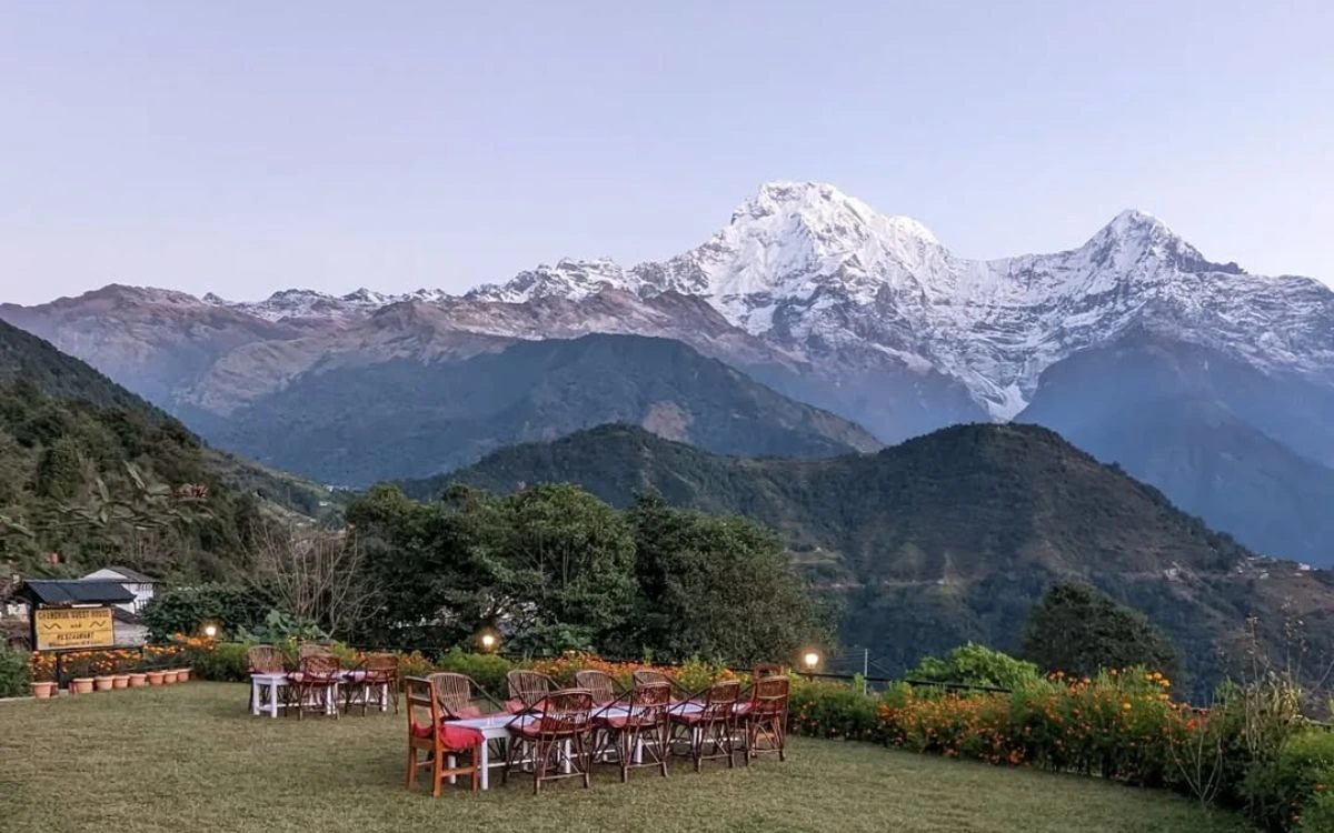 Outdoor dining area with mountain view of snow-covered Annapurna range at sunset in Ghandruk
