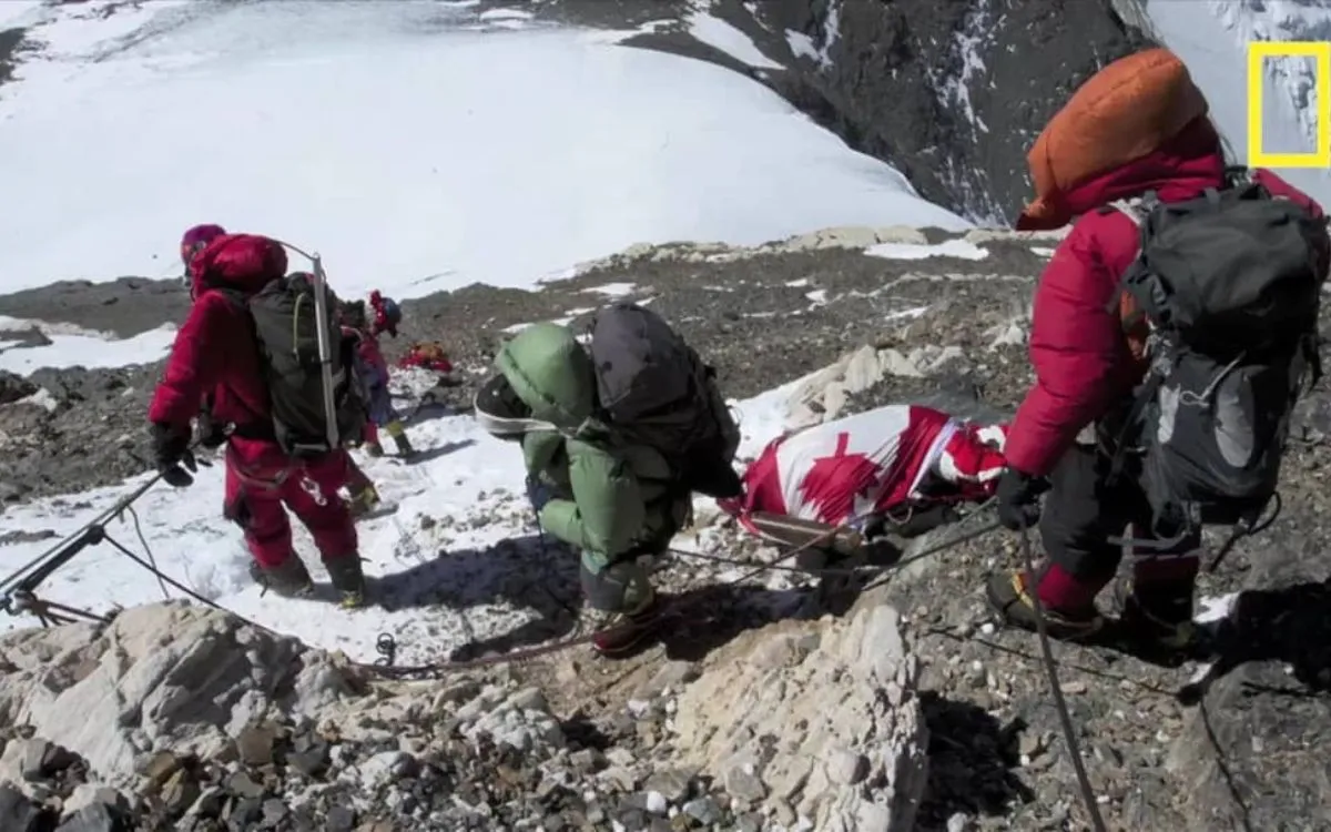 Mountain rescue team conducting evacuation operation on snowy rocky terrain with injured climber on stretcher