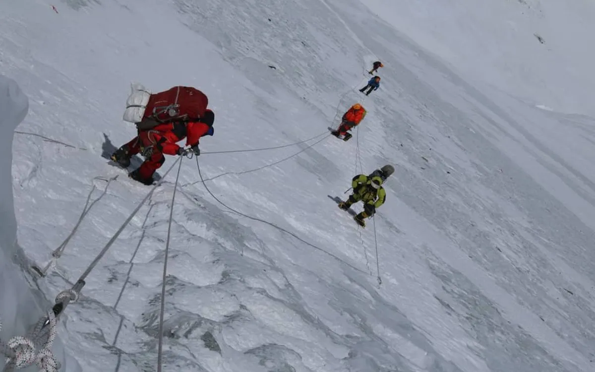 Climbers rappelling down steep icy glacier face using ropes and mountaineering equipment