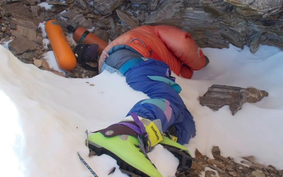 Deceased climber known as 'Green Boots' landmark on Mount Everest, wearing distinctive green mountaineering boots in snow-covered area