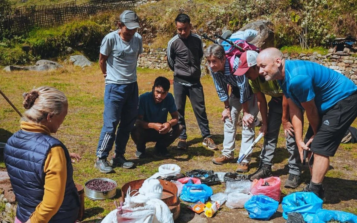A trekking group and guides reviewing food and gear supplies on the ground before a Nepal trek