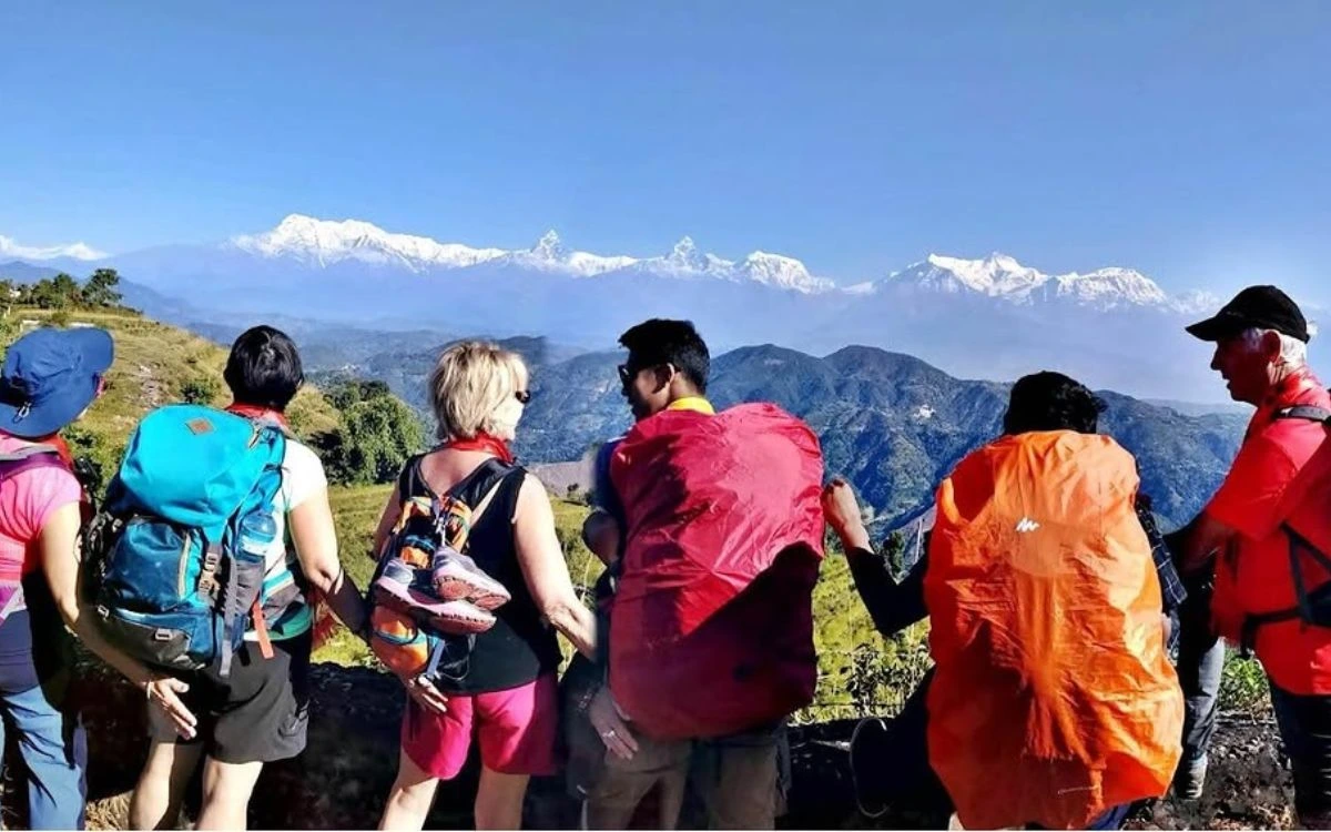 Professional trekking guide explaining route to group of international trekkers with Annapurna mountain range view