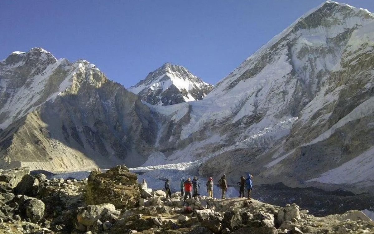 Trekkers at Everest Base Camp with Khumbu Icefall and Himalayan peaks in background