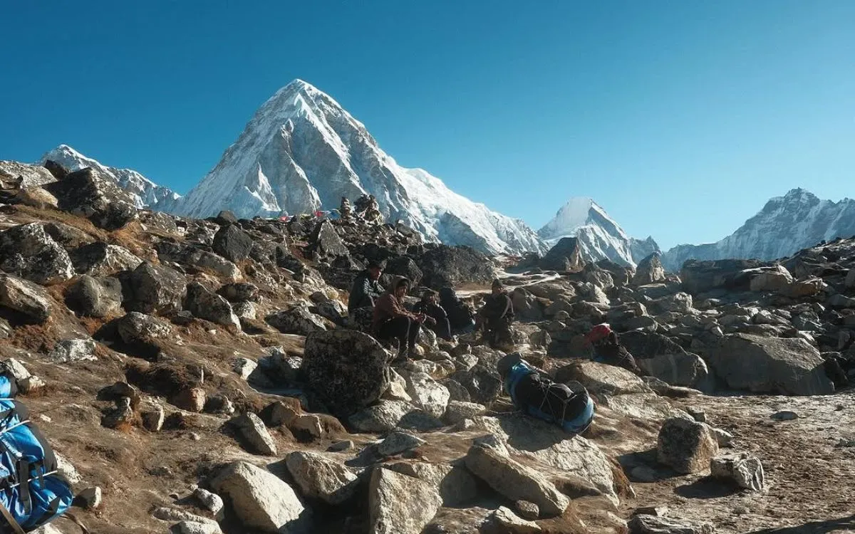 ocky terrain and trekkers on EBC trail with Himalayan summit views
