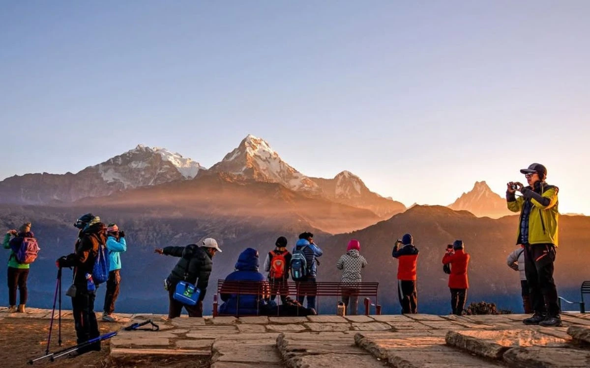 Tourists photographing Annapurna peaks at sunrise from Poon Hill viewpoint