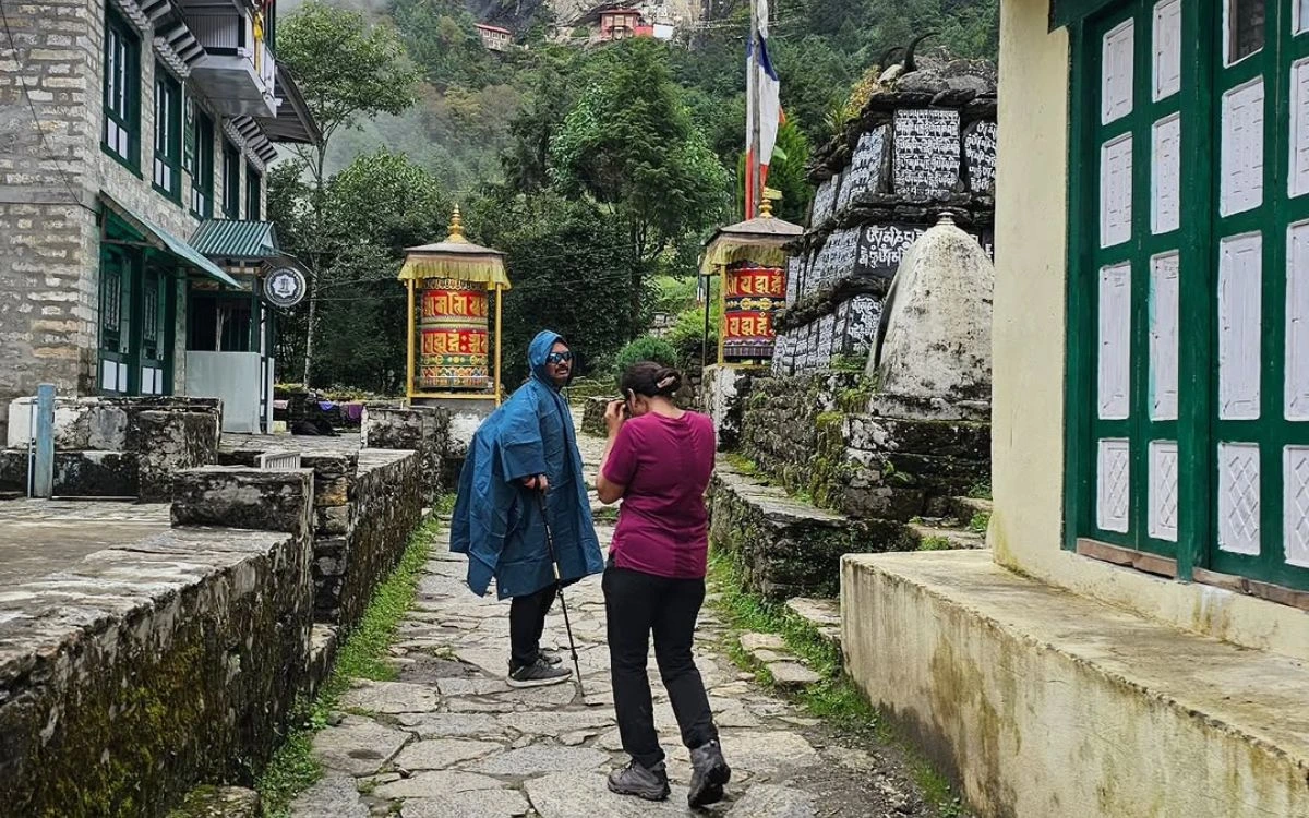 Trekkers walking past prayer wheels on the Everest trail