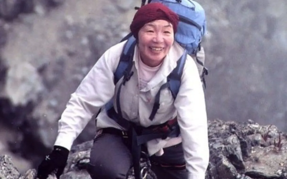 Junko Tabei smiling during a mountain trek in pink hiking gear