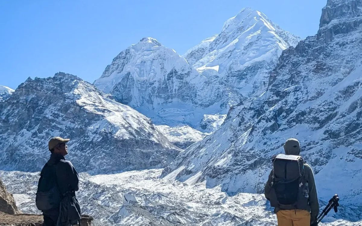 Trekkers viewing Kanchenjunga peaks glacier hiking guide Nepal