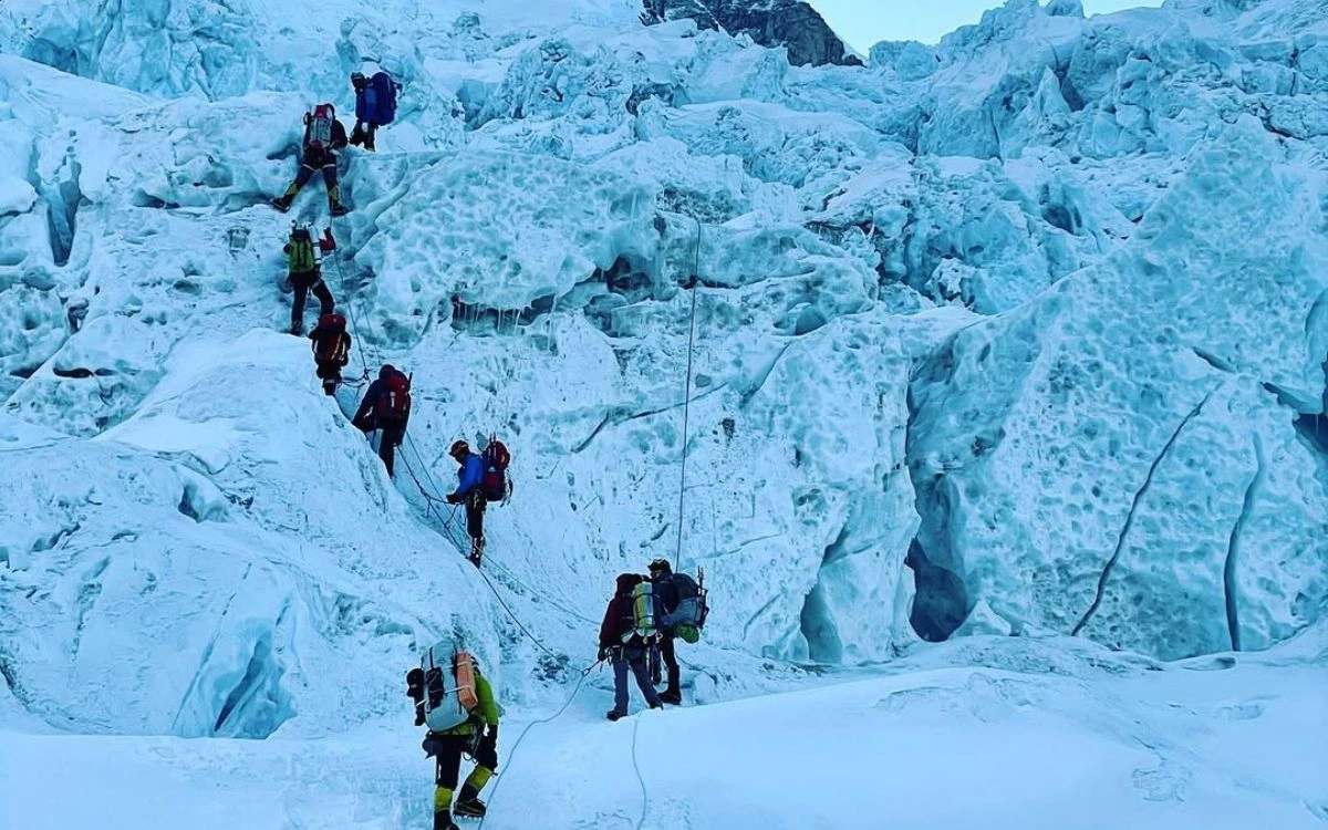 Roped climbers ascending seracs and crevasses through the Khumbu Icefall