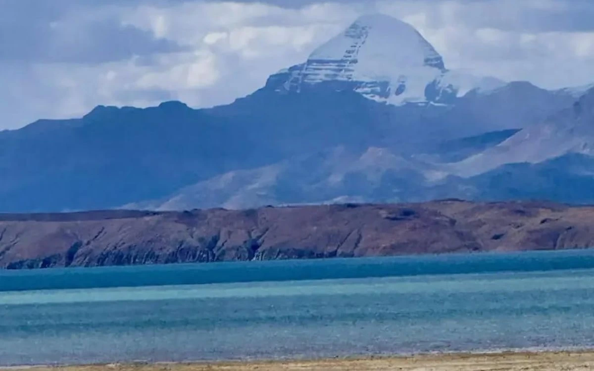 Mount Kailash rising above Lake Manasarovar's turquoise waters