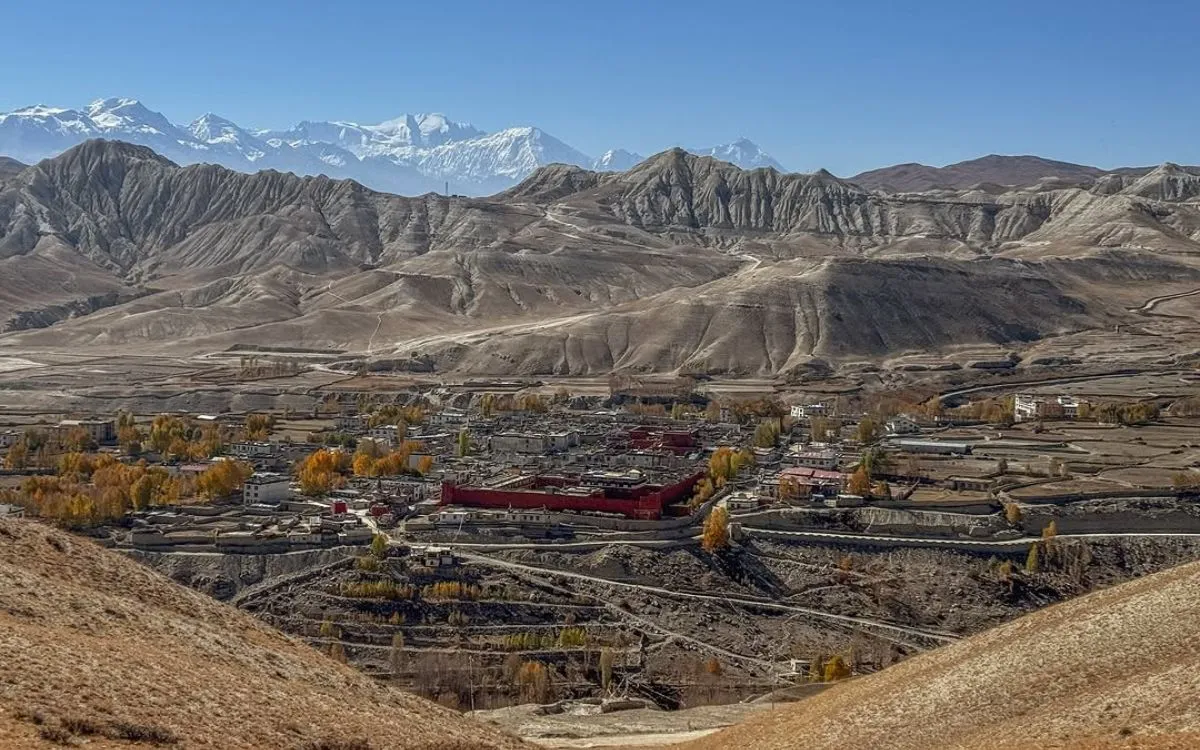 Aerial view of Lo Manthang walled city with traditional buildings and snow-capped Himalayan peaks in background