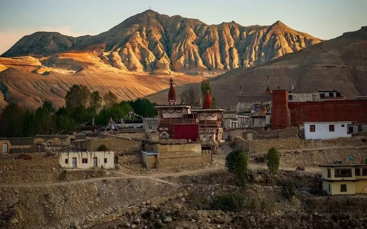 Traditional Tibetan architecture and monasteries in Lo Manthang at sunset with eroded cliffs behind