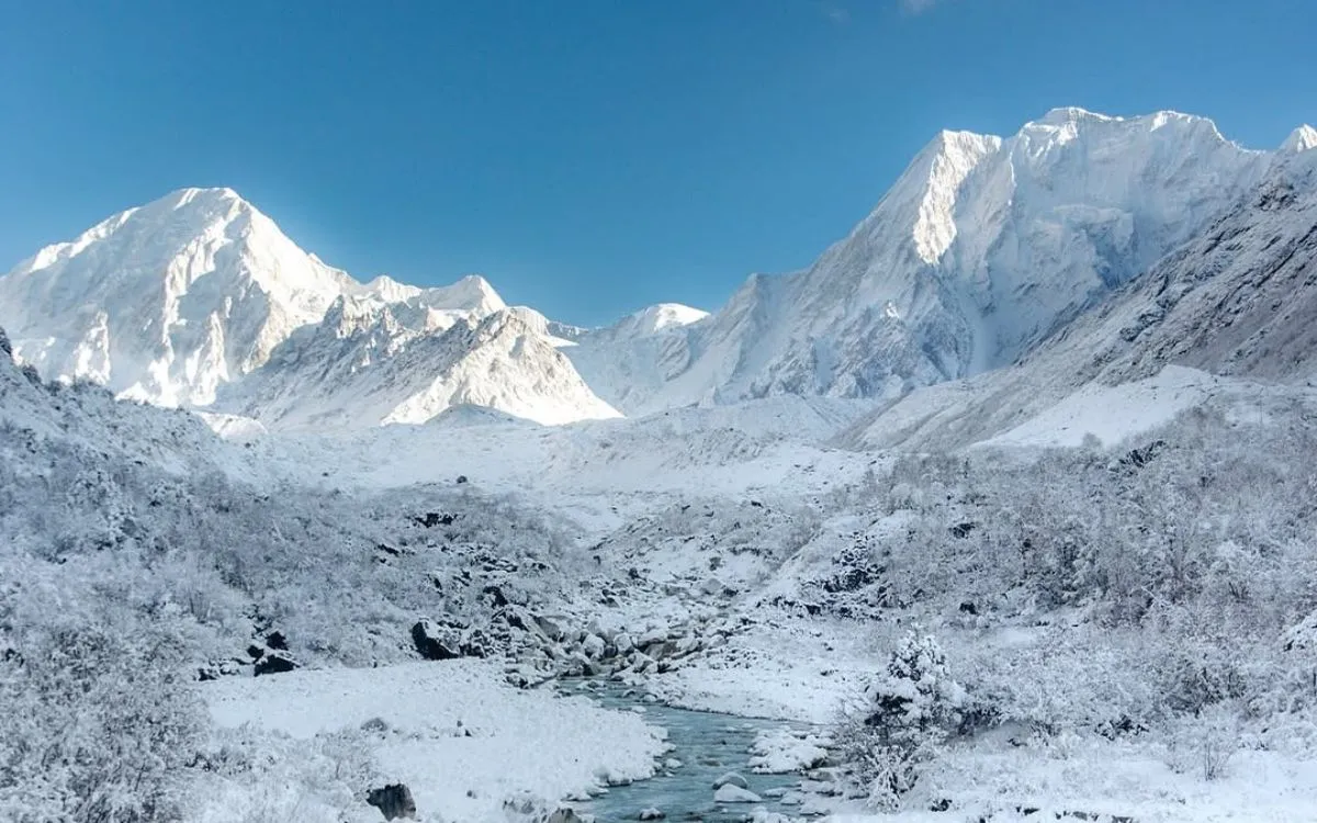 Snow-covered Himalayan mountains with turquoise river flowing through winter landscape on Manaslu Circuit trek Nepal