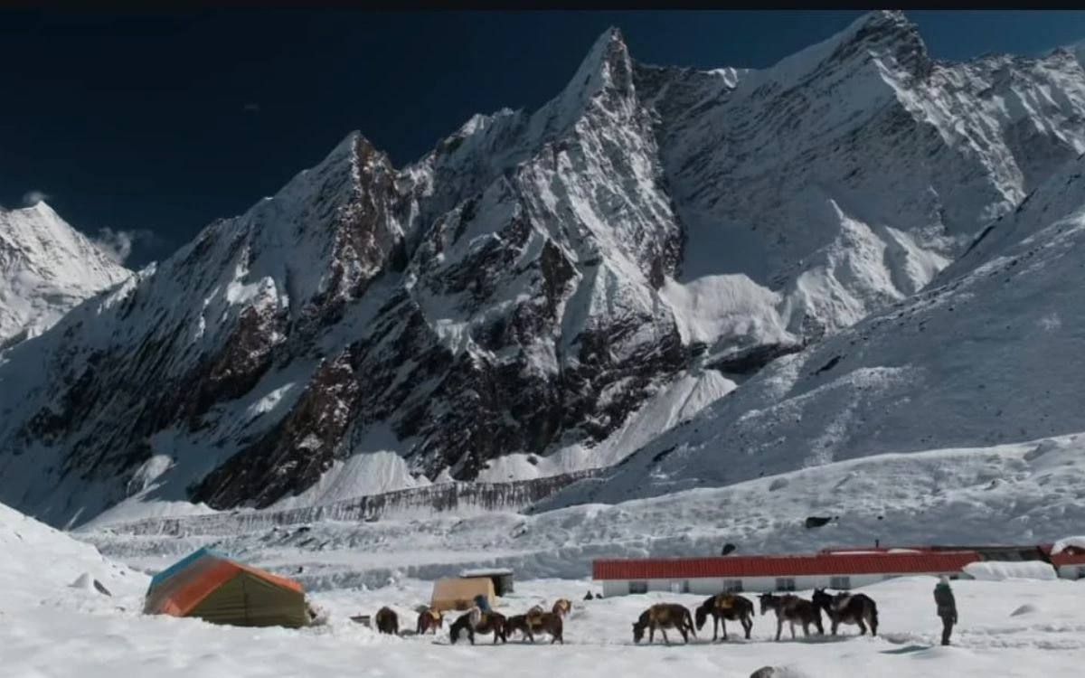 Manaslu Base Camp with pack animals and tents beneath towering peaks