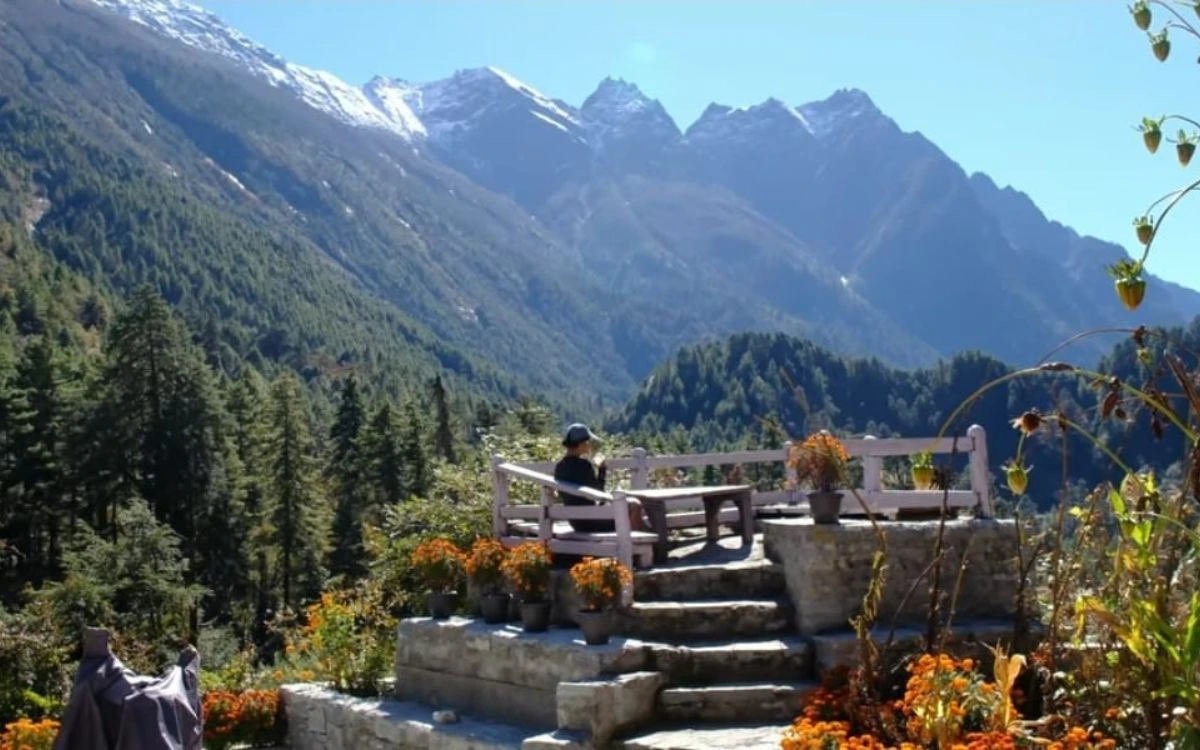 Mountain viewpoint with seating area overlooking forested Manaslu valley