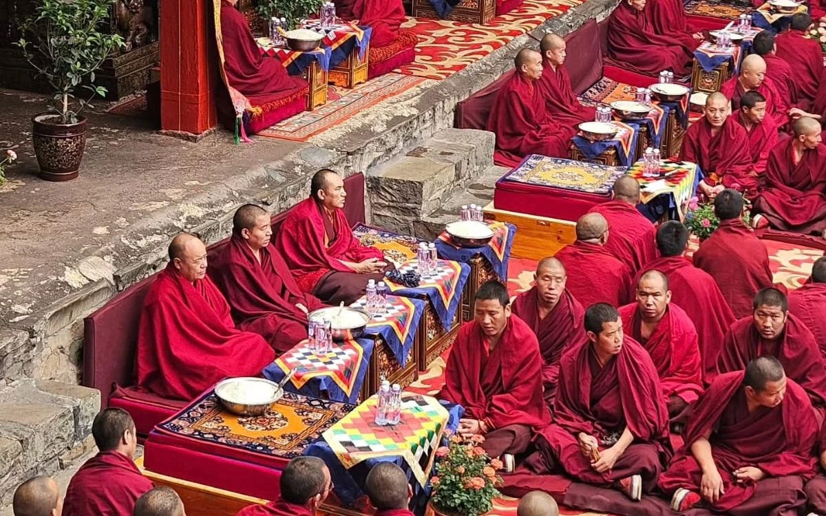 Monks in red robes seated at a Mani Rimdu ceremony
