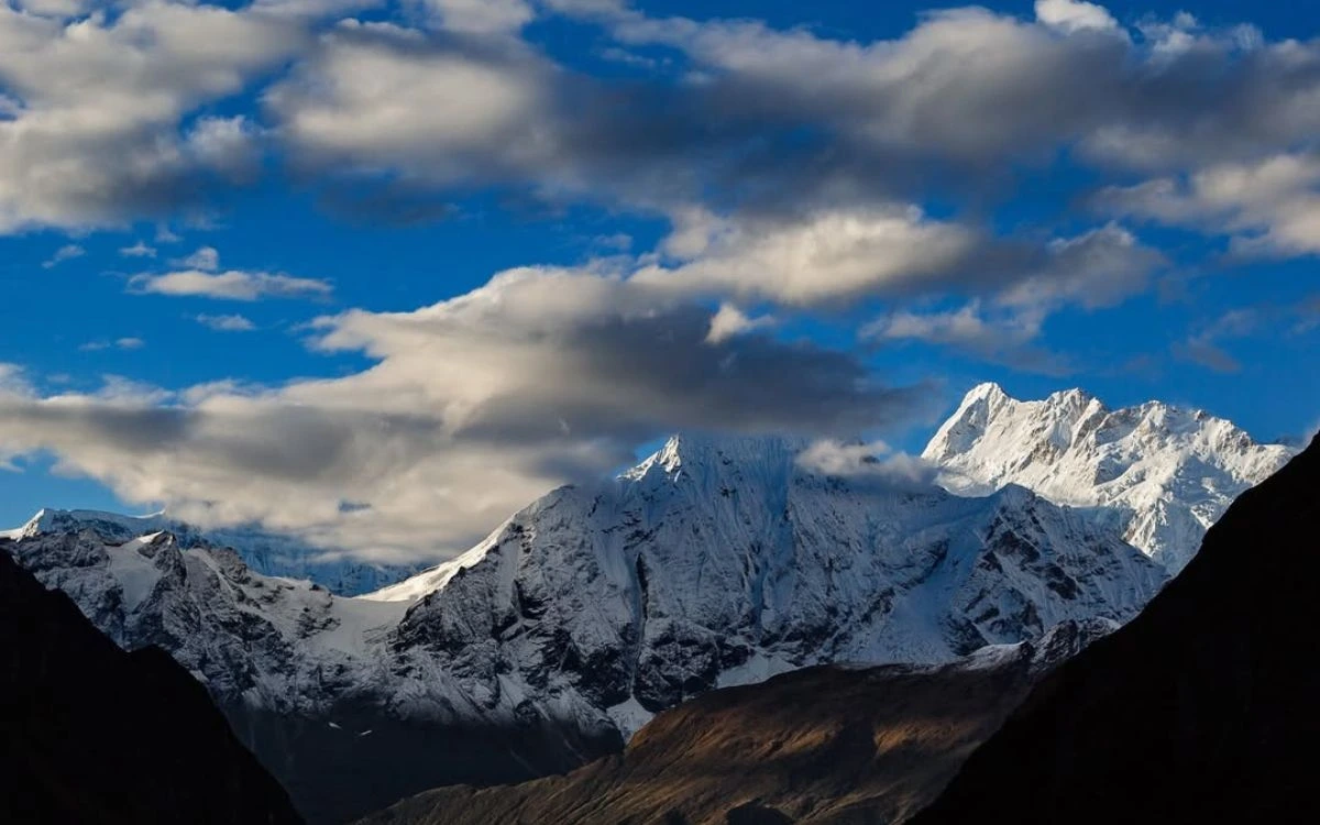 Snow-capped Himalayan peaks under a dramatic cloudy sky