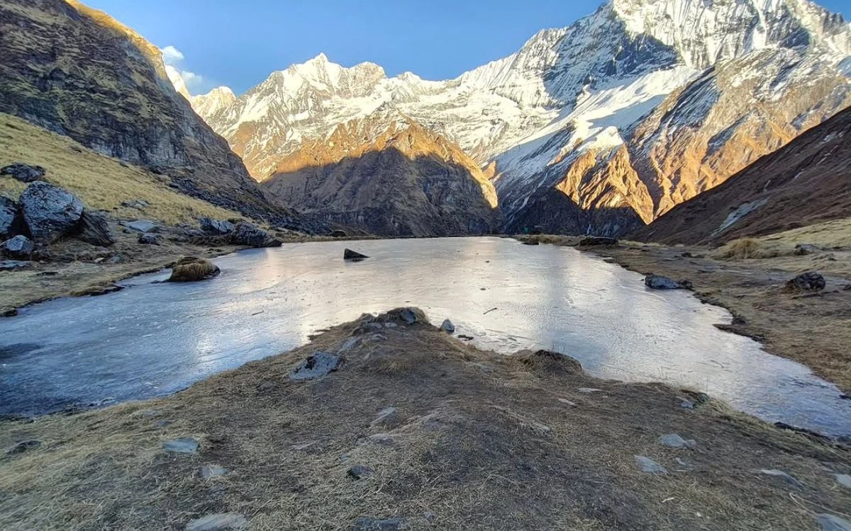 Frozen alpine lake surrounded by snow-covered mountain peaks