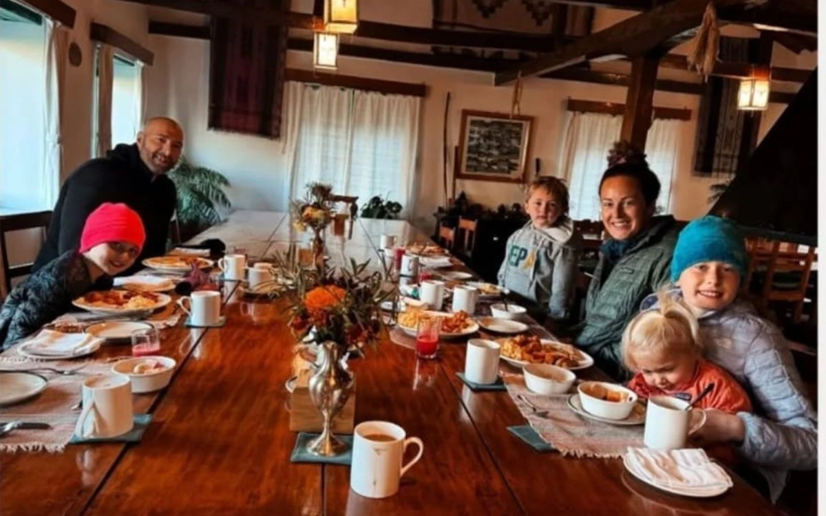 Family with children enjoying a meal together at a teahouse dining table in Nepal