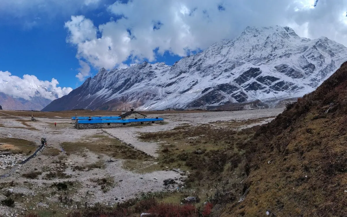 Remote teahouse with blue roof in Manaslu trekking region Nepal surrounded by snow-capped mountains
