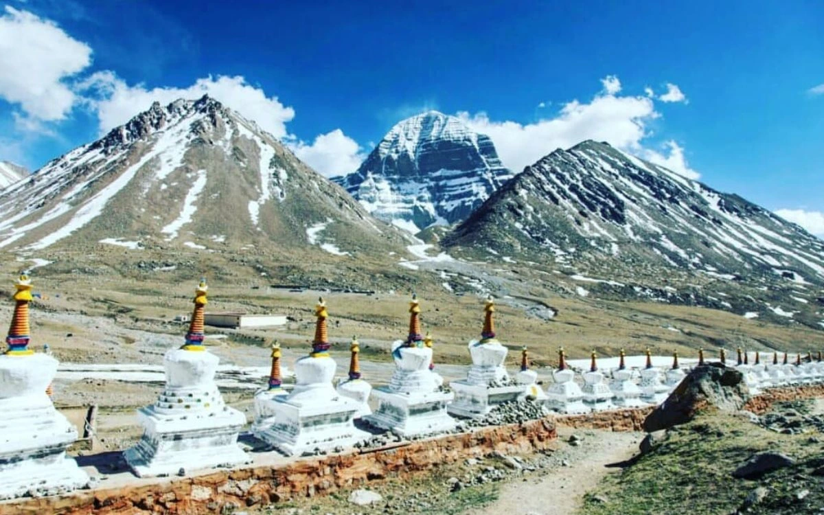 Row of white stupas with Mount Kailash rising behind