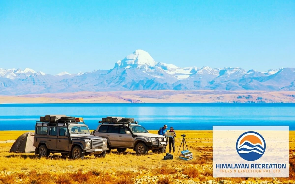 Overland vehicles parked beside Lake Manasarovar with Mount Kailash behind