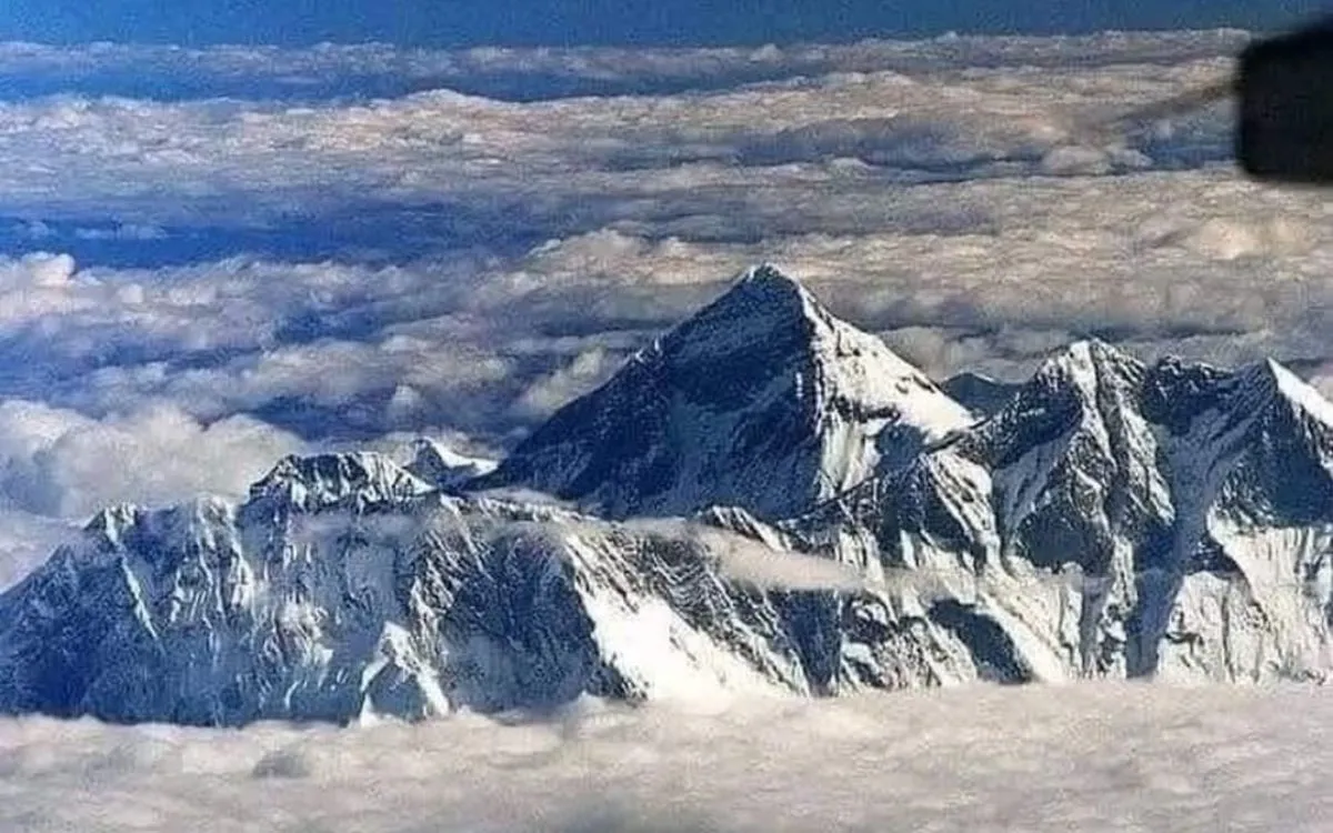 Aerial view of Mount Everest's pyramid summit above clouds